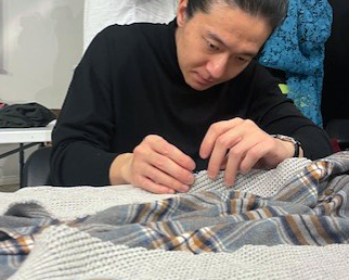 Community Member, Kuang, working on his first sewing project!