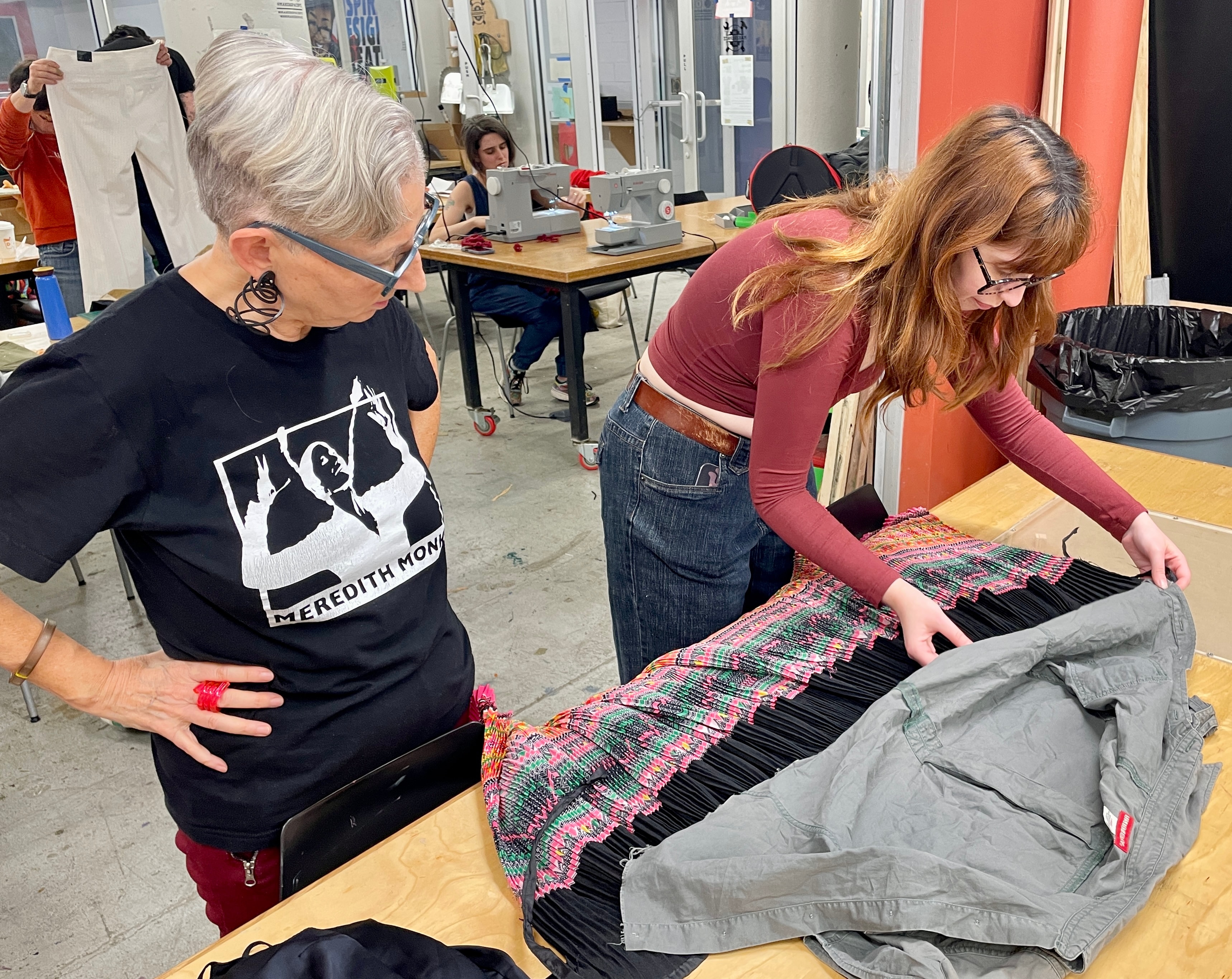 Women examining woven textile in workshop