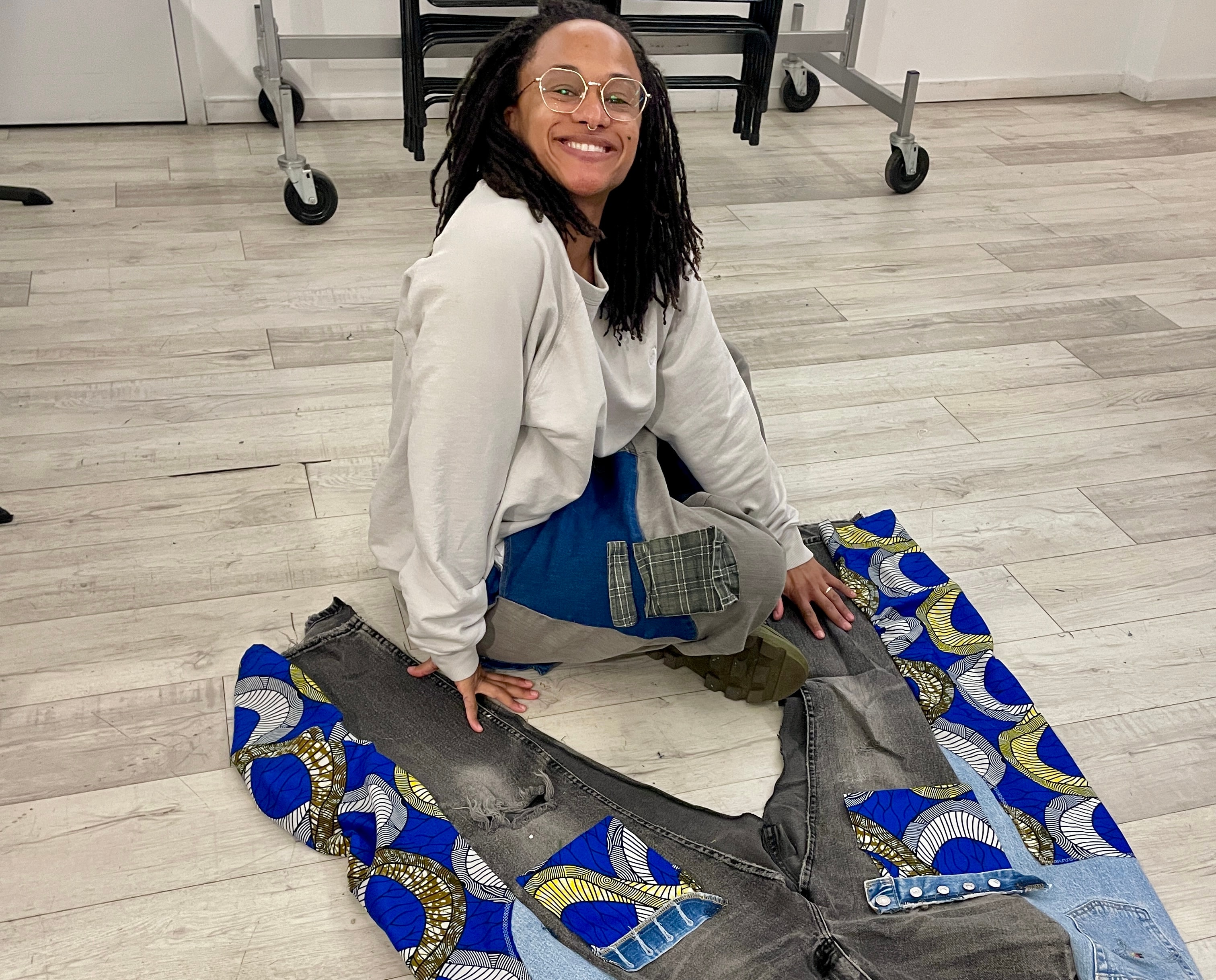 Woman displaying patchwork jeans on floor