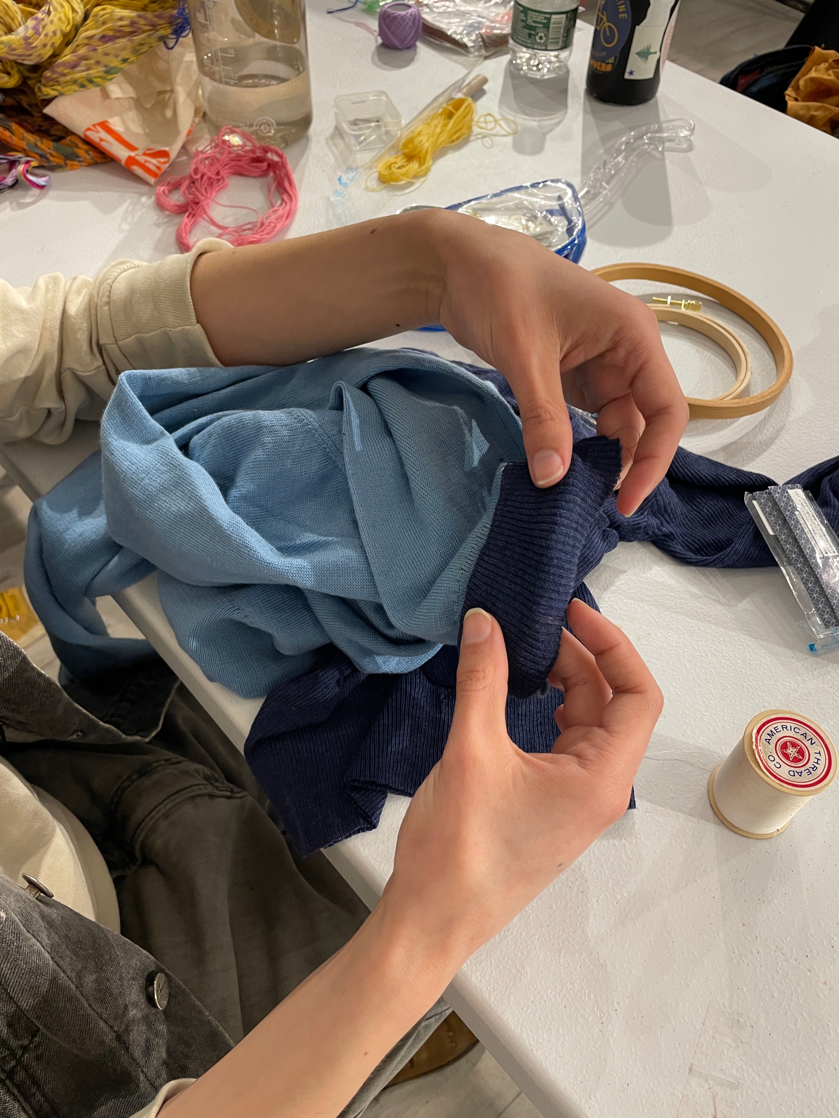 Hands holding blue navy fabric scraps