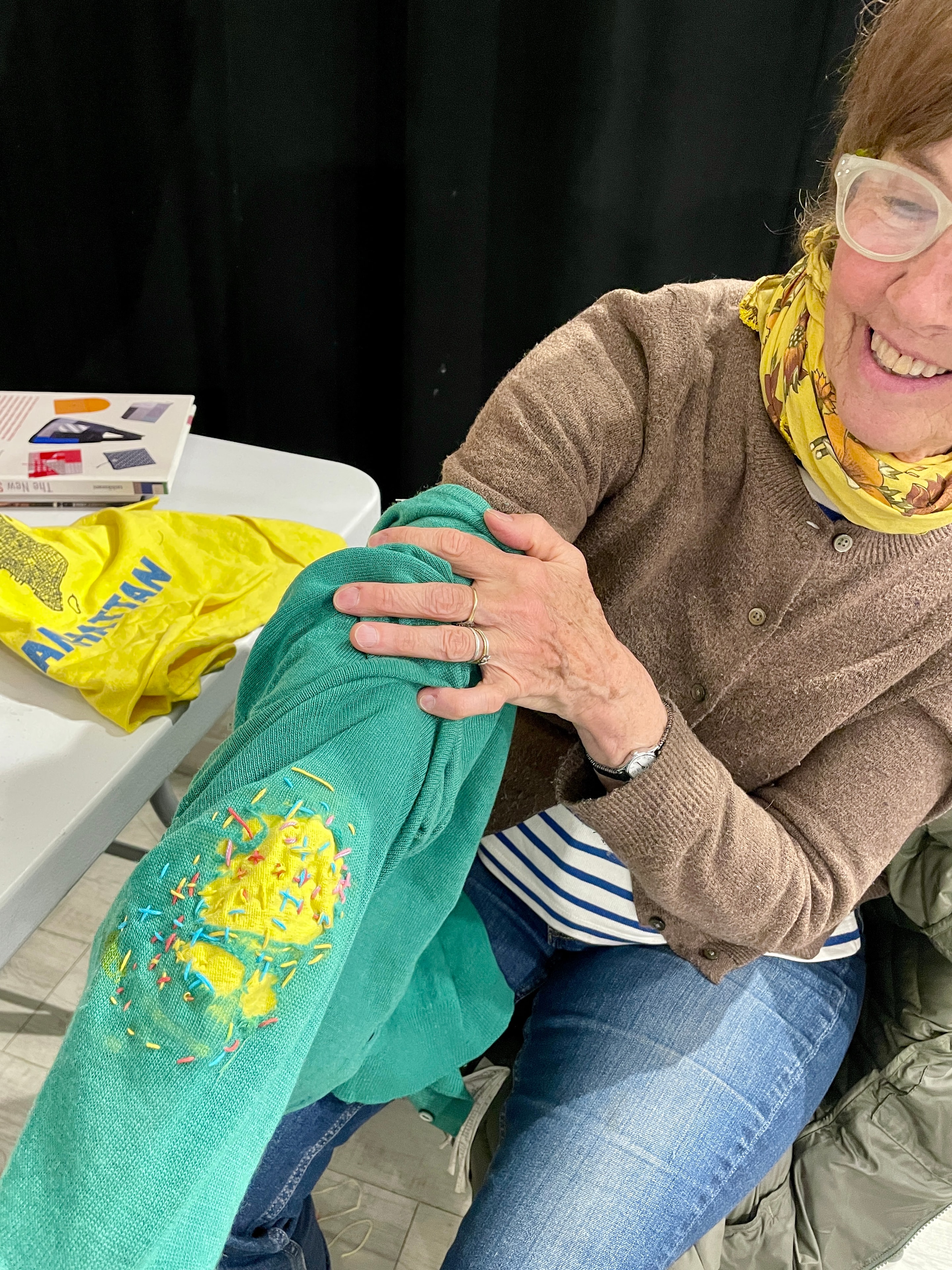 Woman displaying green embroidered garment